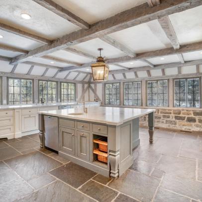 Tudor Estate Kitchen With Wraparound Windows and Exposed-Beam Ceiling 