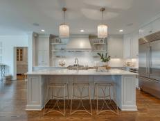 White eat-in kitchen with wide island and elegant pendants.
