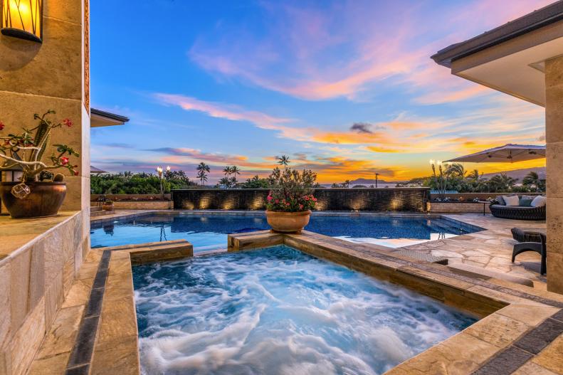 Square hot tub with view of Hawaiian sunset across pool. 