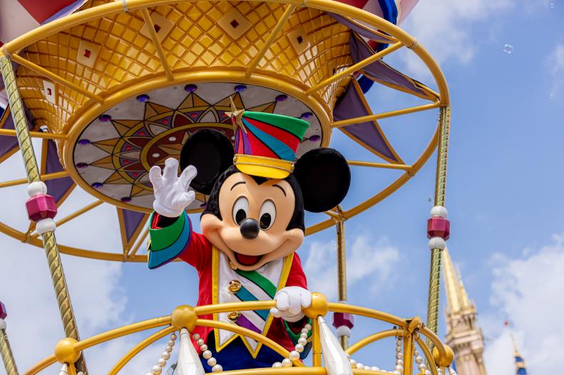 Mickey Mouse waves to the crowd during the “Disney Festival of Fantasy Parade” in Magic Kingdom Park at Walt Disney World Resort in Lake Buena Vista, Fla. The parade returned to the park Wednesday, March 9, 2022, after a nearly two-year absence. (Courtney Kiefer, photographer)