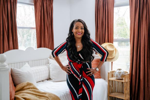 As seen on HGTV's Bargain Block, Shea Hicks-Whitfield poses in the primary bedroom before a tour of the Hampton House.