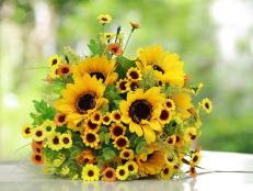 Luxury bouquet ,beautiful bouquet of bright yelloe flowers, plastics flower,on  wooden table with nature green background.