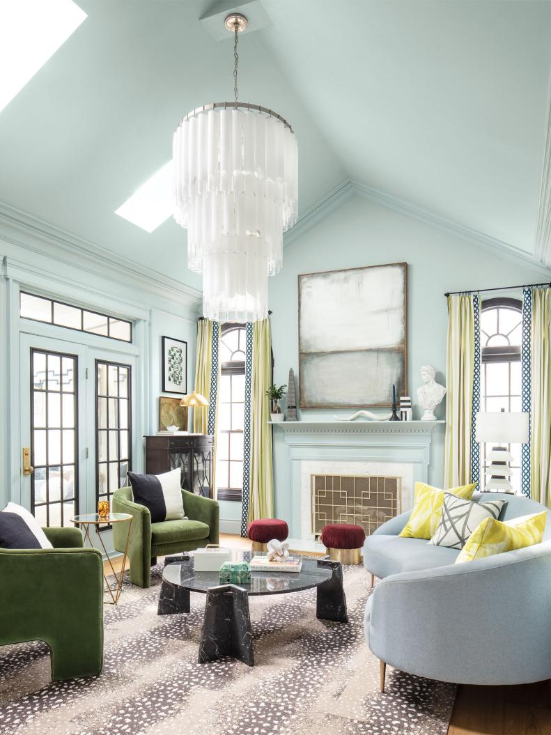 Eclectic living room with light blue walls and ceiling and dramatic chandelier.