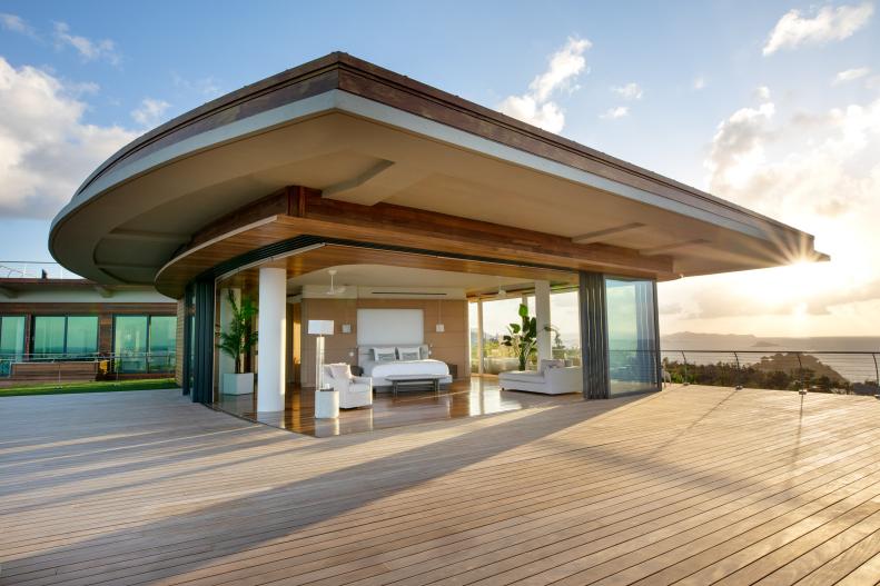 Flat-roofed suite with retractable glass walls and wide wooden deck.