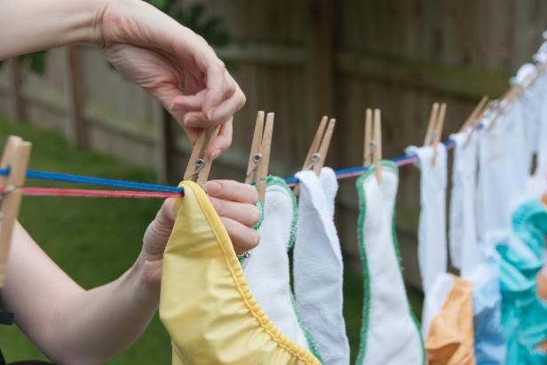 Cloth Diapers on a Clothesline - It is laundry day! A mom hangs cloth diapers on a clothesline to dry in the sun.