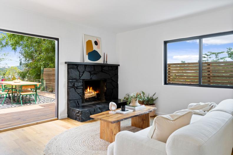 A white living room with a painted black stone fireplace