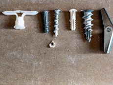 assortment of different drywall anchors used for hanging objects on walls