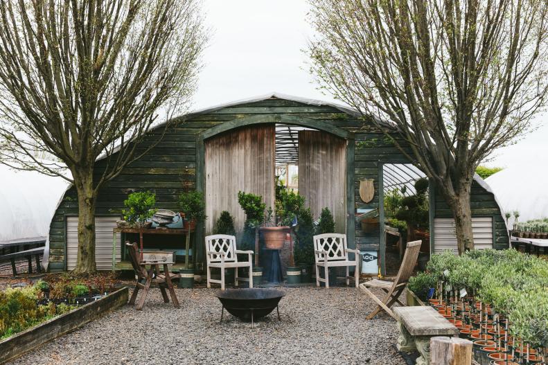 A Greenhouse With a Wooden Exterior and Sitting Area