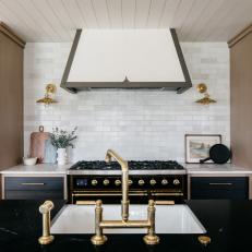 Black, White and Brown Kitchen Features a Plaster and Metal Range Hood