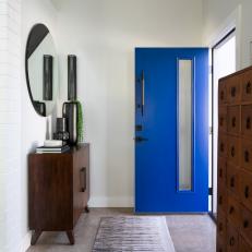Mid-Century Modern Foyer Features a Blue Front Door and Midcentury Console Table