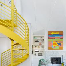Living Room With Striking Yellow Spiral Staircase and Vibrant Art