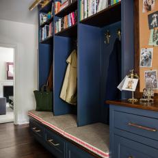 Blue Mudroom With Brass Coat Hooks and Upholstered Bench Seating
