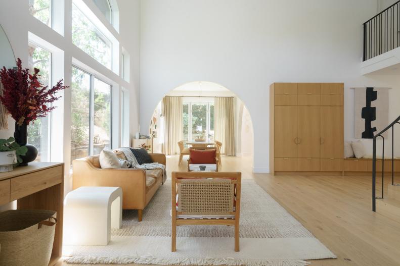 Neutral Wood Entry, Leather Sofa and Chairs Opposite Modern Staircase