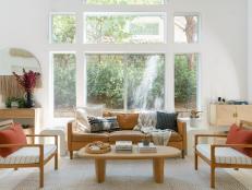 Wall of Windows in Neutral Living Room, Leather Sofa, Wooden Chairs