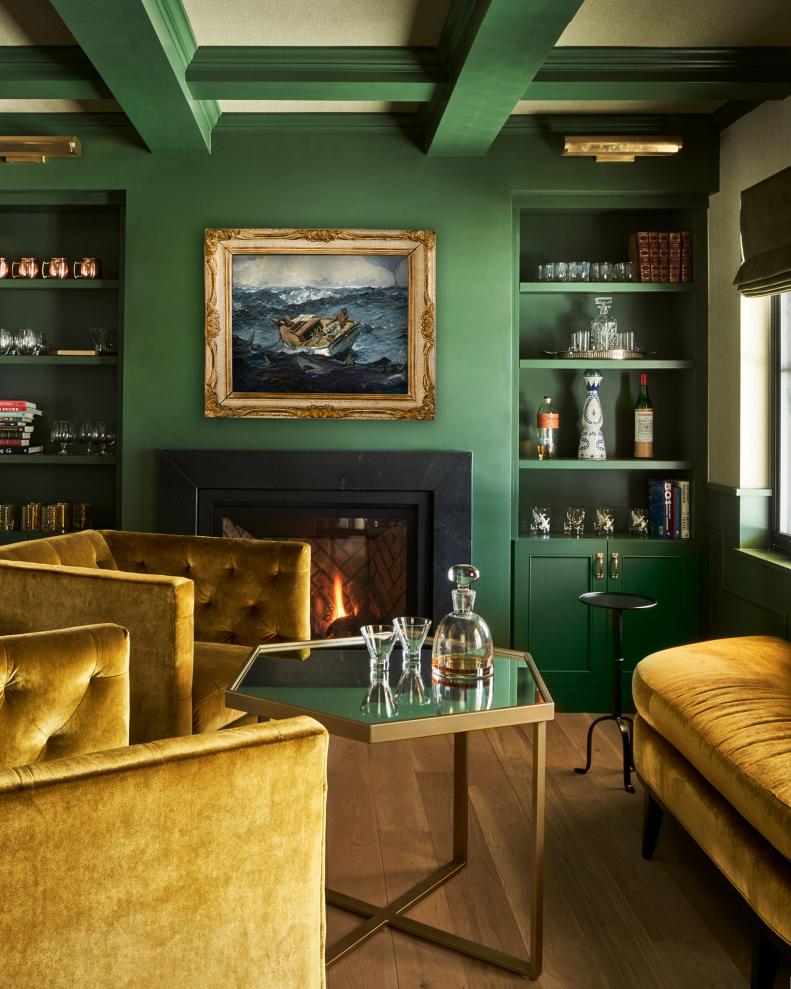 Fireplace in Dark Green Home Bar, Built-Ins With Spirits, Velvet Sofas