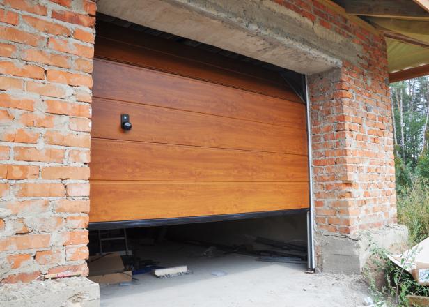 Installing garage door in new brick house construction. 