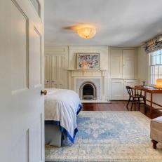 White Historic Farmhouse Bedroom With Marble Fireplace and Hardwood Floors