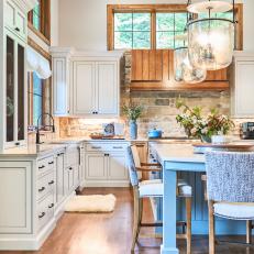 Rustic, White Cottage Kitchen With Stone Backsplash and Mercury Pendants