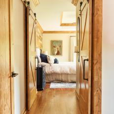 Rustic, White Bedroom With Wooden Barn Doors and Deer Art