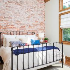 Rustic, White Cottage Bedroom With Exposed Brick and Patriotic Pillows