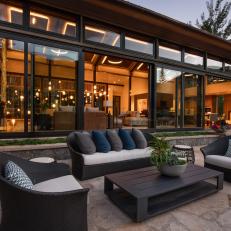 Contemporary Stone Terrace With Black Furniture and Glass Doors