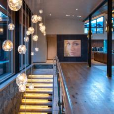 Contemporary Glass-Railed Stairway With Twinkling Pendant Lights