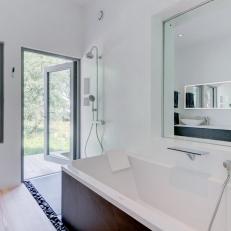 Modern White Bathroom With Bathtub and Patio Access