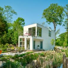 Contemporary White Poolhouse With Outdoor Lounge and Wetland Landscape