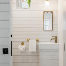 Small White Bathroom With Gold Accents and Tulips