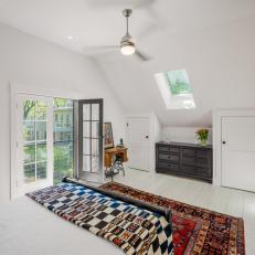 Cottage Bedroom Featuring A Vintage Rug and Large Windows