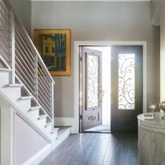 Spacious Entryway With Stairs and Wooden Doors