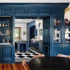 Contemporary Dining Room With Deep Blue Cabinets and Chandelier