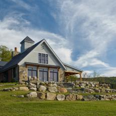 Agrarian-Inspired Home With Gable Roof and Rock Walls