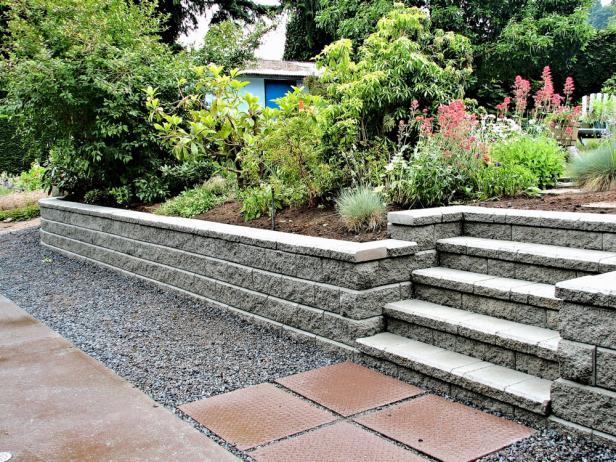 A beautiful closeup view of a staircase incorporated into a block retaining wall with steps leading into existing landscaped garden 