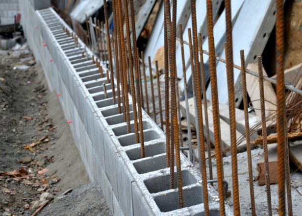 unsightly road notch of the bridgehead. retaining wall with concrete grouting and drainage. fencing with hollow bricks filled with wires, railings, foundation, cover the old ugly industrial zone