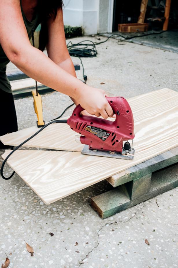 Woman cutting plywood with jigsaw