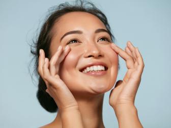 Young Asian Woman Applying Sunscreen