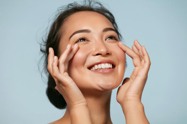 Young Asian Woman Applying Sunscreen
