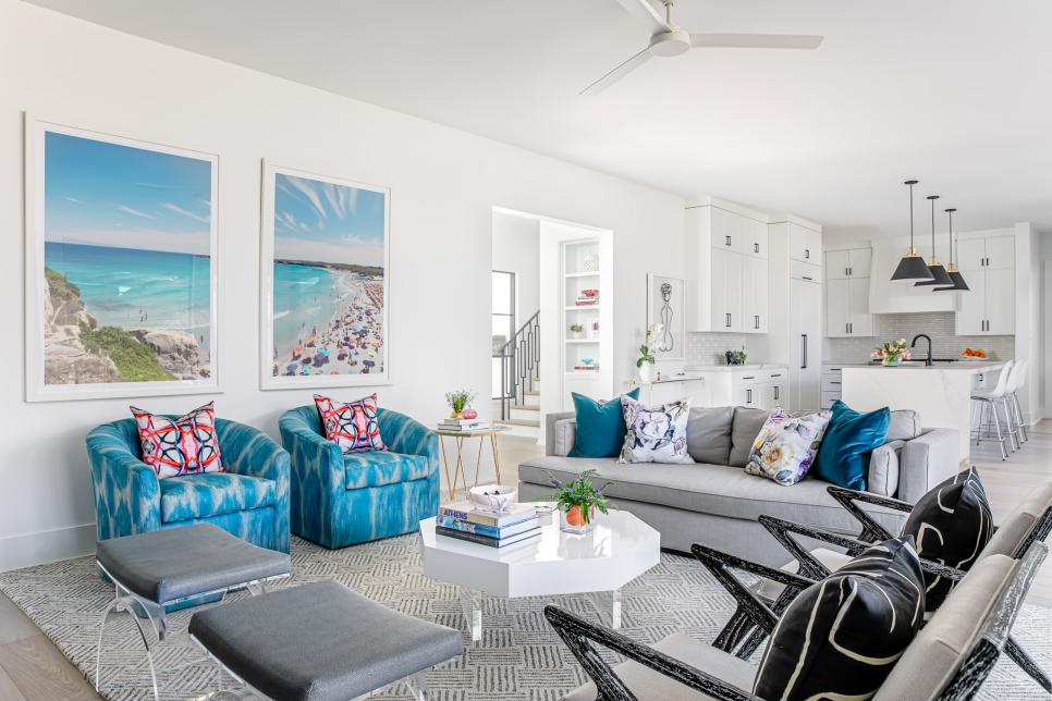 White Open-Plan Living Room With Beach Photos and Vibrant Blue Chairs