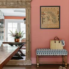 Pink Dining Room With Antique Mirror and a Small Patterned Bench