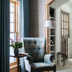 Traditional Plaid Armchair Sits in Front of a Large Window With Blue Curtains
