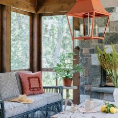 Screened Porch With Stone Fireplace and an Orange Light Fixture
