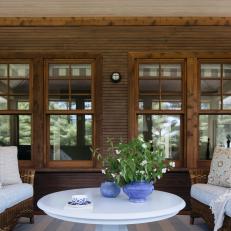A Rustic Wood Paneled Porch Features Windows and a Sitting Area