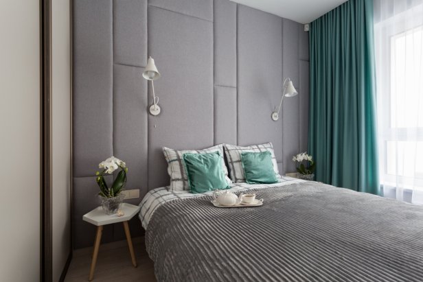 Interior of a small cozy bedroom with grey padded wall