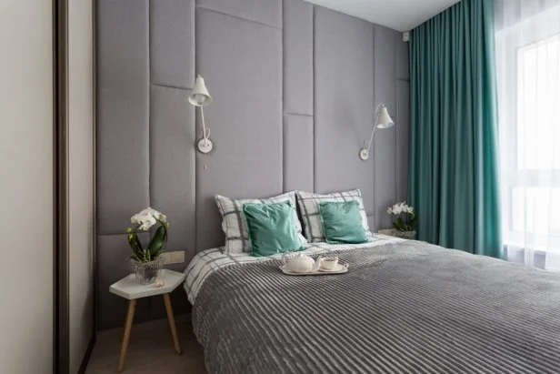 Interior of a small cozy bedroom with grey padded wall