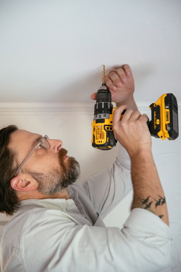 Drill a pilot hole into the ceiling.