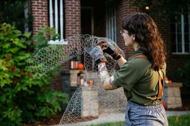 Chicken wire is rolled and connected to resemble a ghostly figure for a DIY Halloween decoration.