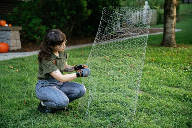 Chicken wire is cut and twisted together as part of a DIY Halloween decoration.