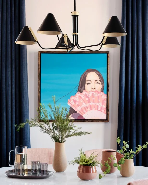 A dash of local Nashville style is added with the Kacey Musgraves album cover inspired painting that flanks the dining room wall. A mix of potted plants brings life and color to the space and adds an outdoor element to the indoor gathering space.