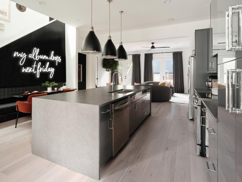 Lightly stained wood floors keep the space feeling bright and open while natural light fills the space from banks of windows on either end of the kitchen area.